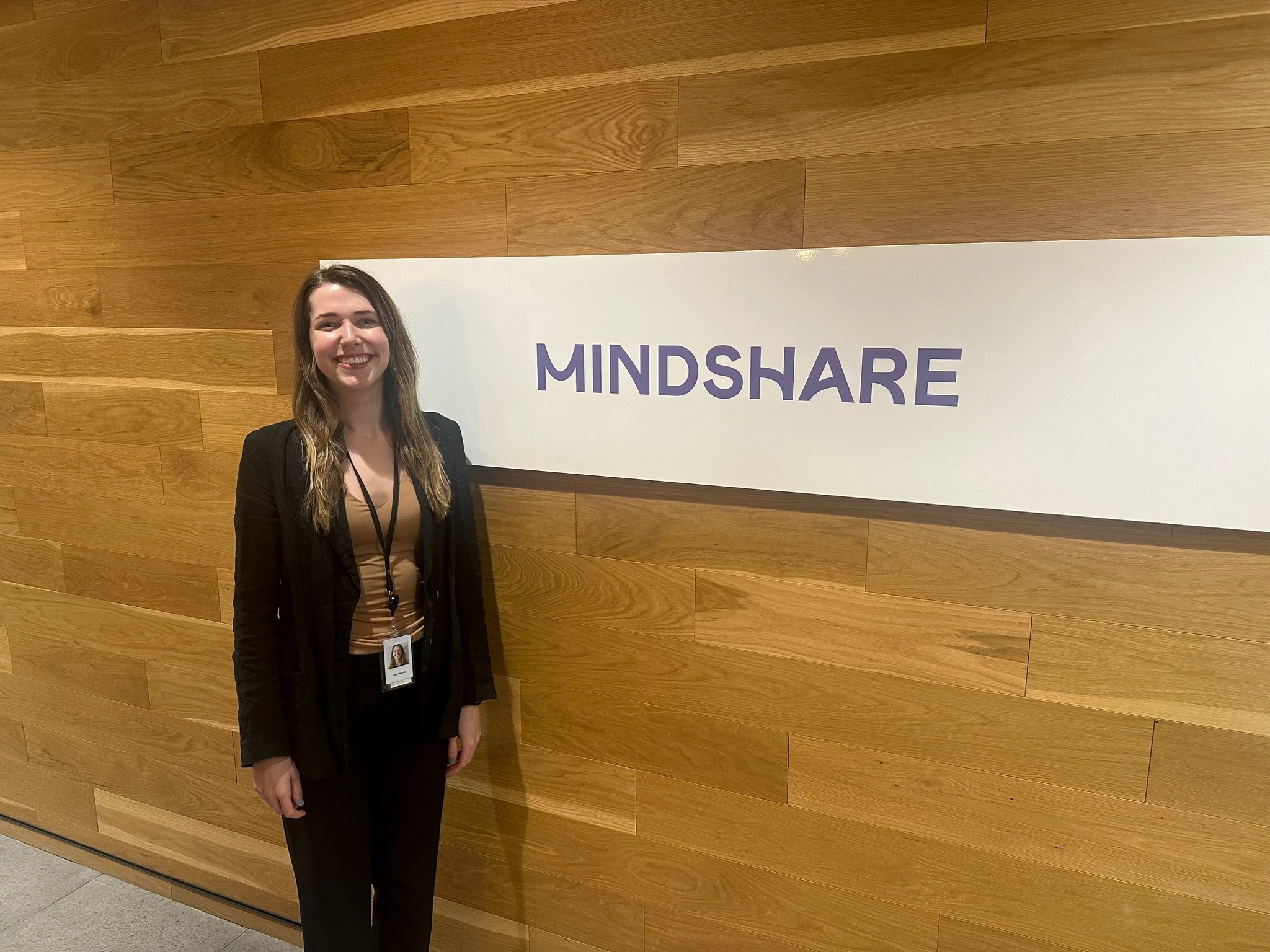 Erika standing beside the Mindshare sign at GroupM
